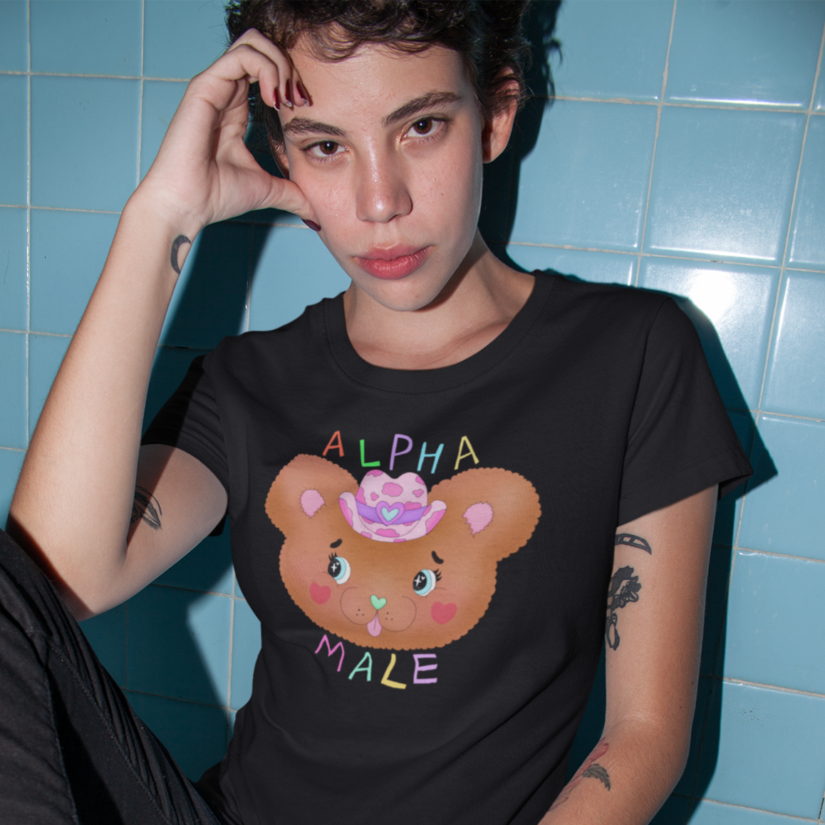 Black pride tee featuring an illustrated cowboy teddy bear featuring the words alpha male in rainbow writing. shop feminist trash for pride merch and funny political clothing