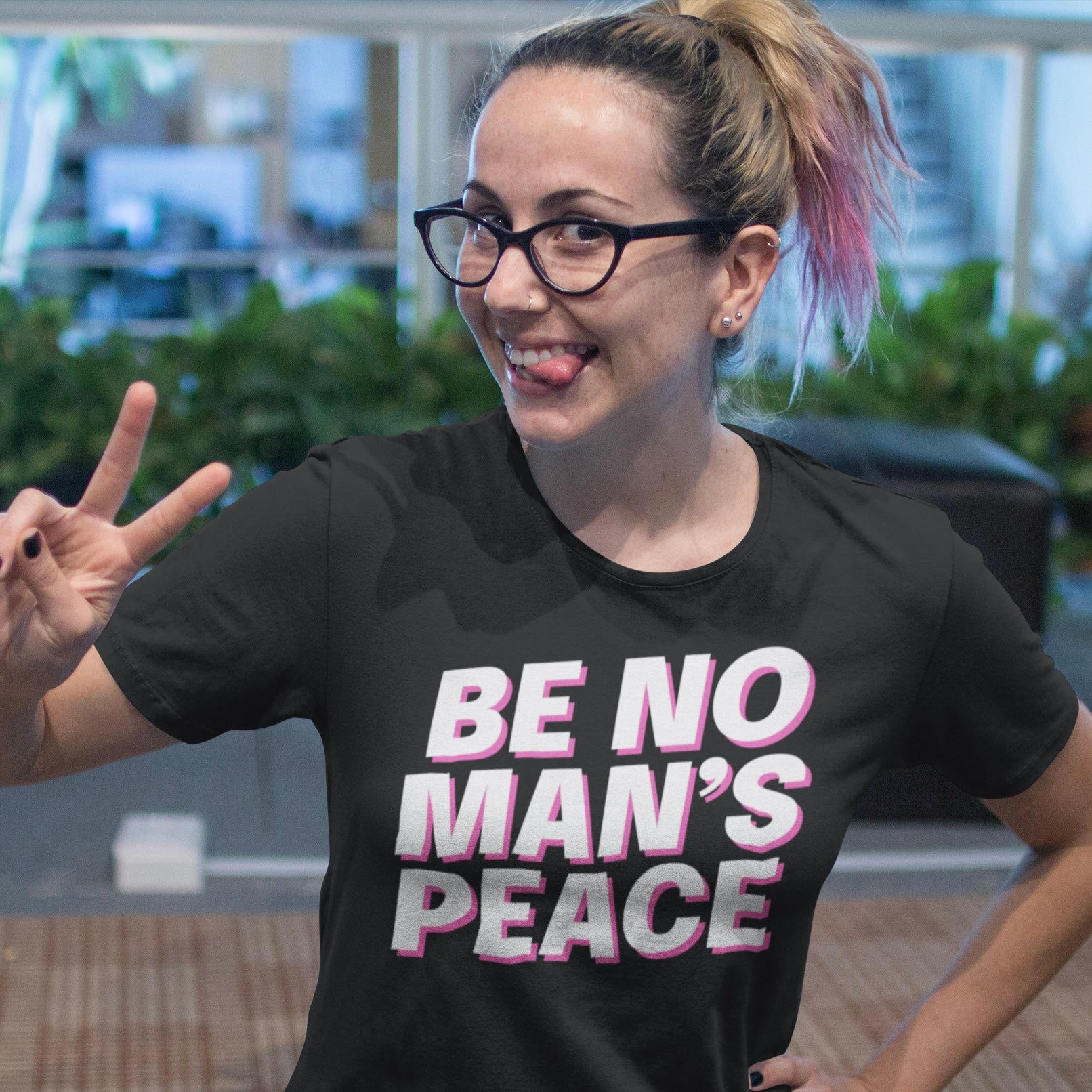 Black feminist tee that says be no man's peace in bold white writing with pink accents- Shop feminist apparel