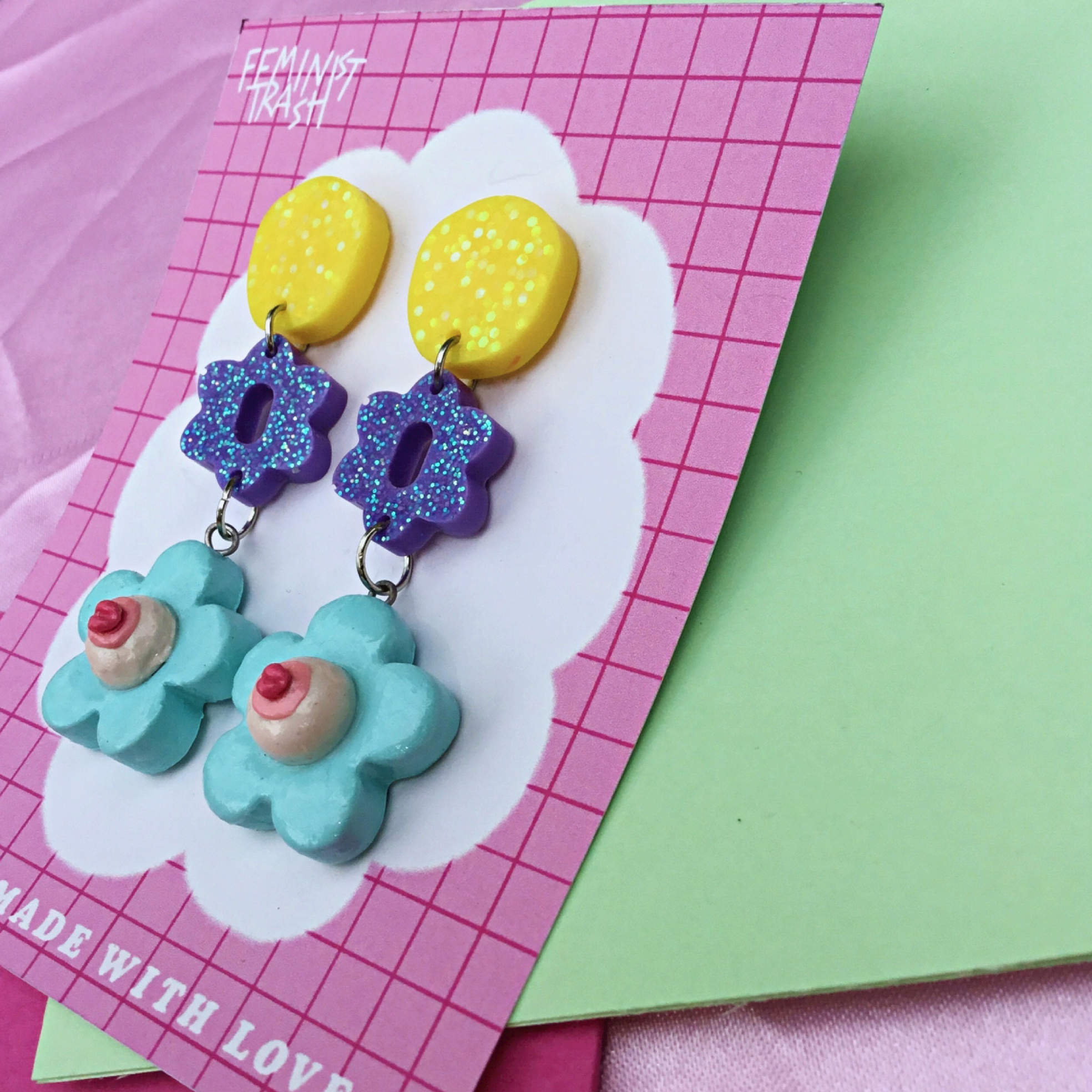 hand sculpted daisy nipple feminist earrings featuring glitter resin dangle elements. shop feminist jewellery for the empowered woman