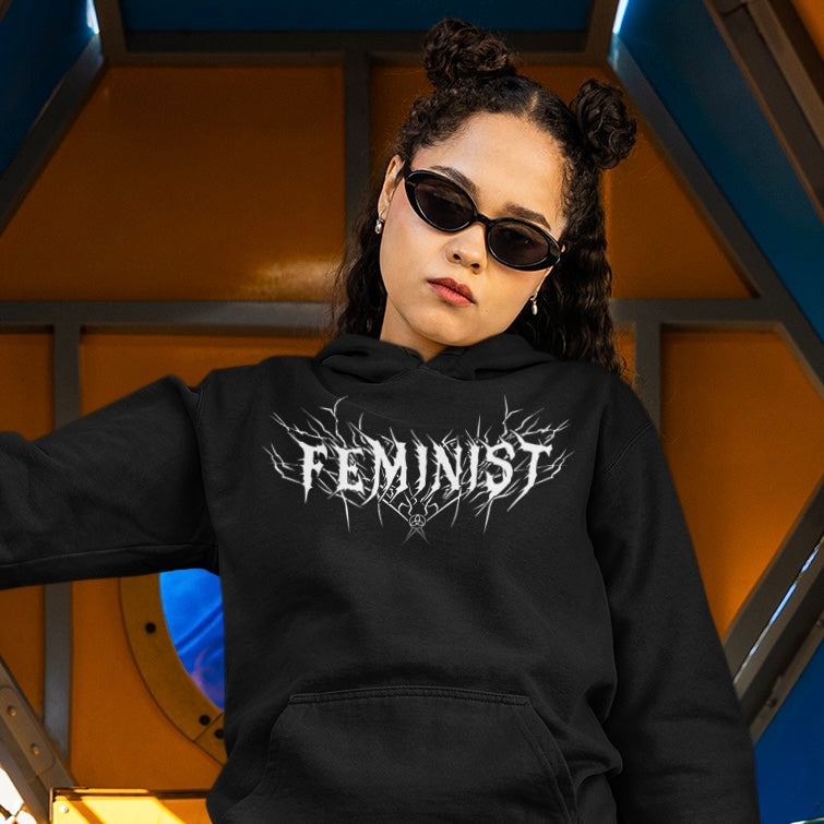 black feminist hoodie that says feminist in white heavy metal writing- shop feminist trash for feminist apparel, dump him shirts, political clothes and pride merch