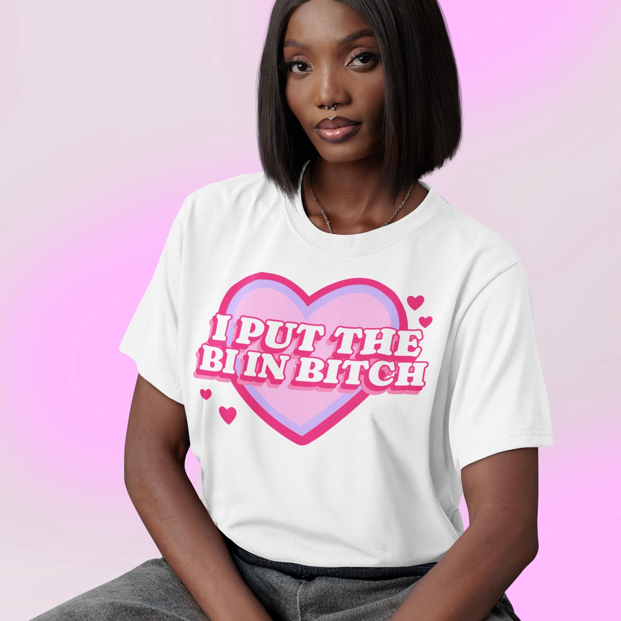 bisexual tshirt in white that says i put the bi in bitch in whit retro writing on top of a retro pink and purple heart graphic. Shop Feminist Trash Store for pride merch, bisexual pride merch, and outfits for pride.