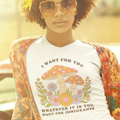 white political tshirt that says I want for you whatever it is you want for immigrants in cooper black writing. Featuring a 70's groovy style mushroom floral illustration. Shop Feminist Trash for Political T-shirts and acab shirts.