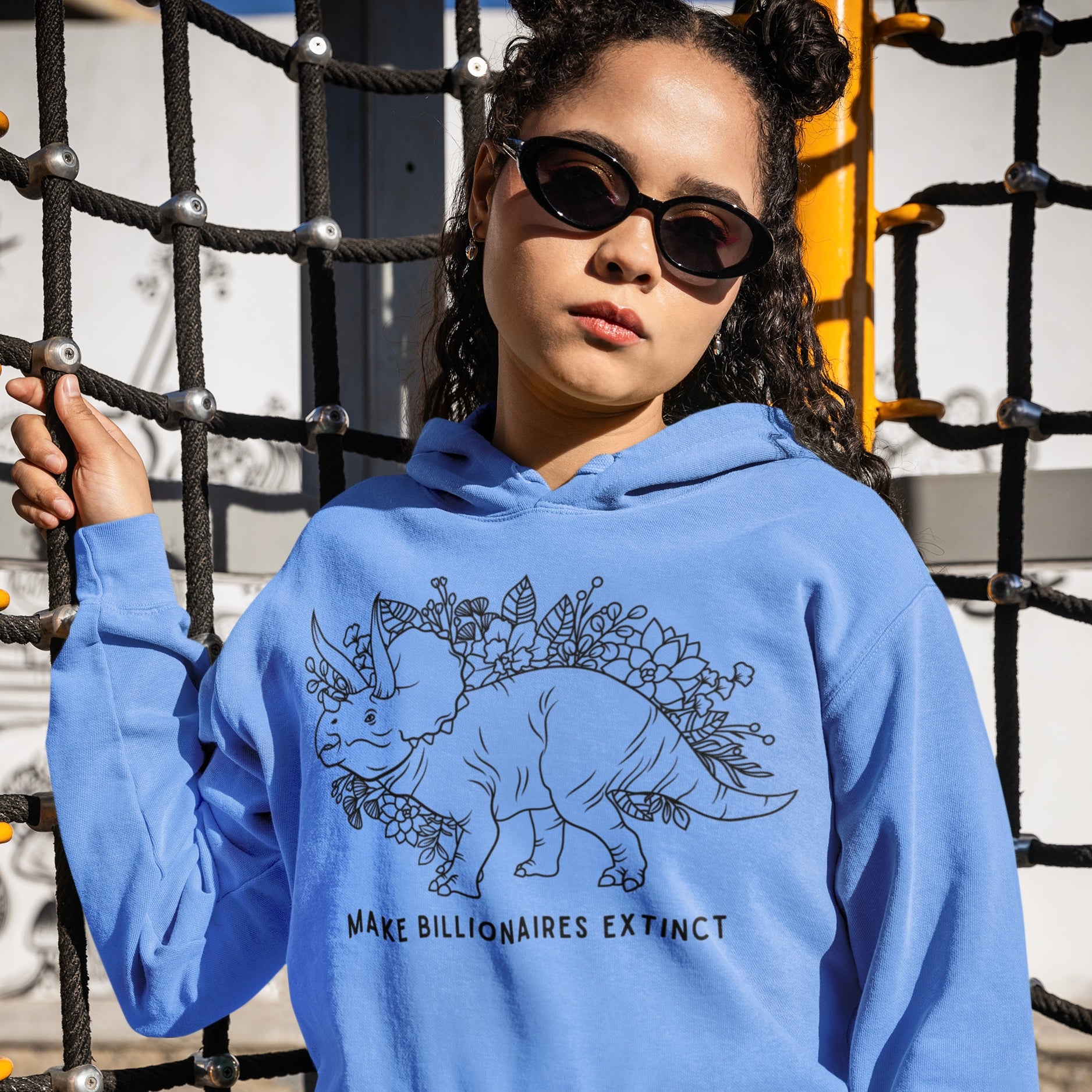 blue hoodie that says make billionaire extinct in black writing featuring an illustration of a triceratops surrounded by flowers- shop feminist trash for political clothes, feminist hoodies and pride merch