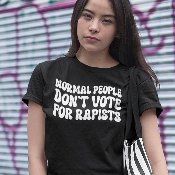 Black political tshirt that says normal people don't vote for rapists in white retro writing- shop feminist trash for feminist t-shirts, political clothes and pride merch