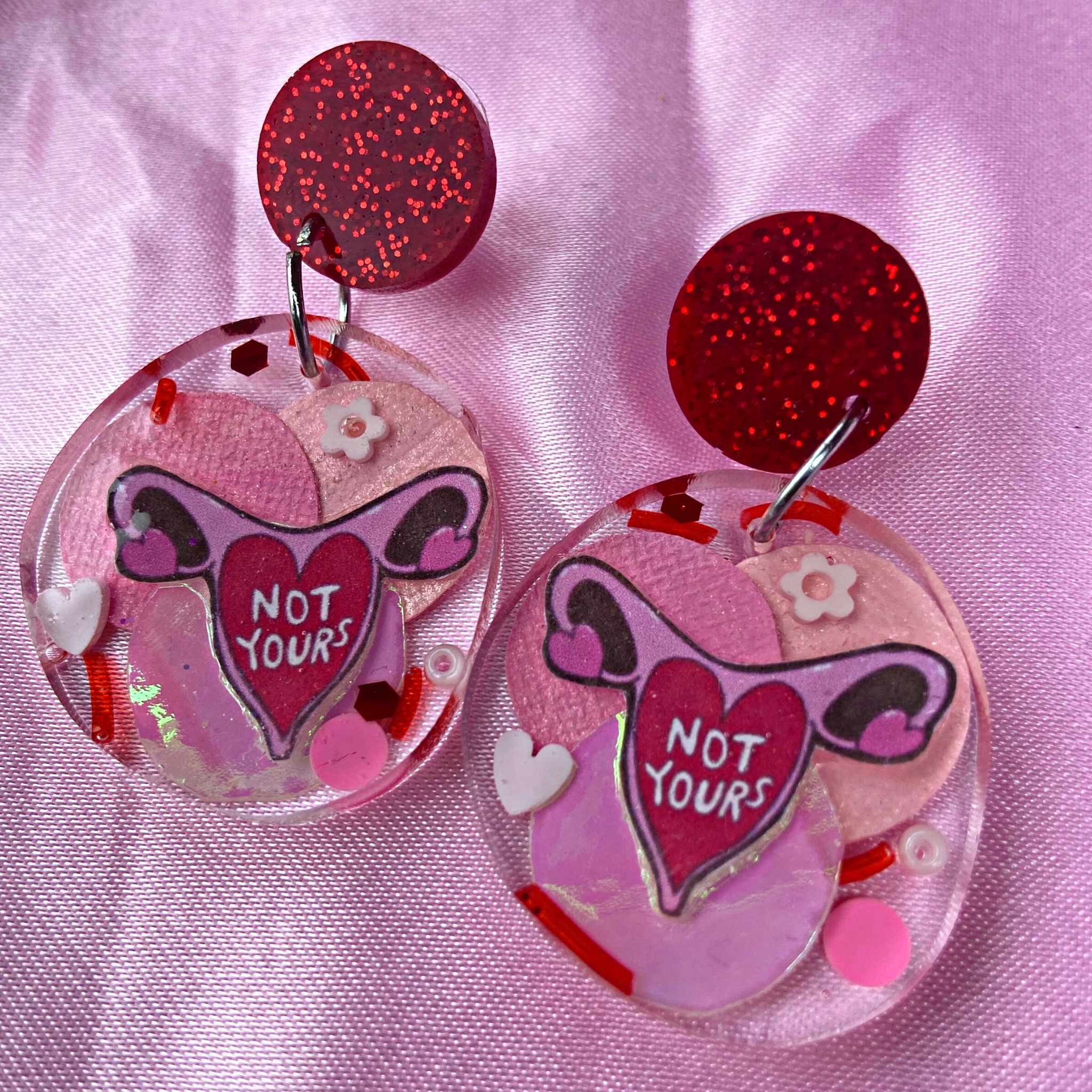 These super cute resin, red glitter feminist earrings features an ovary illustration with not yours written in the centre. Shop feminist jewellery for the empowered woman.