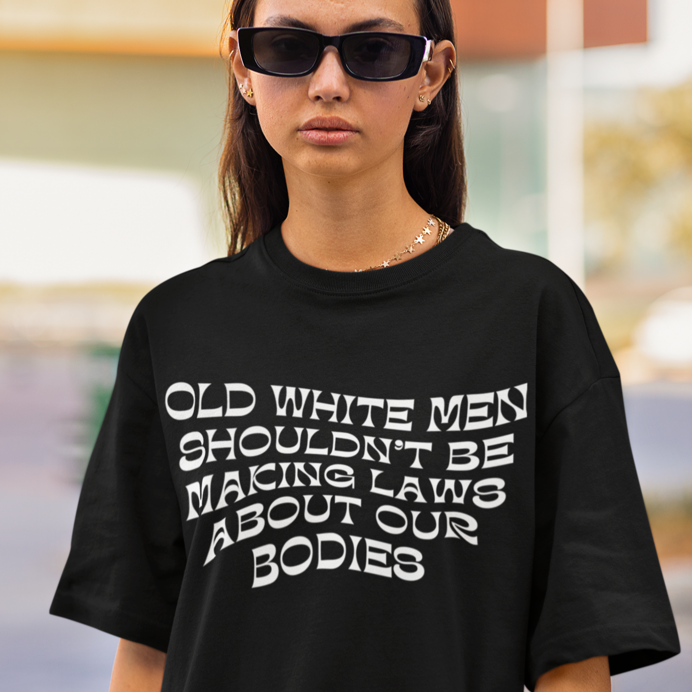 Black feminist tee that says Old White Men Shouldn’t Be Making Laws About Our Bodies in white wavy writing. This is a Unisex Feminist t-shirt - Shop Women’s Rights T-shirts