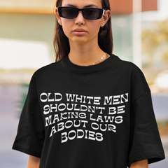 Black feminist tee that says Old White Men Shouldn’t Be Making Laws About Our Bodies in white wavy writing. This is a Unisex Feminist t-shirt - Shop Women’s Rights T-shirts