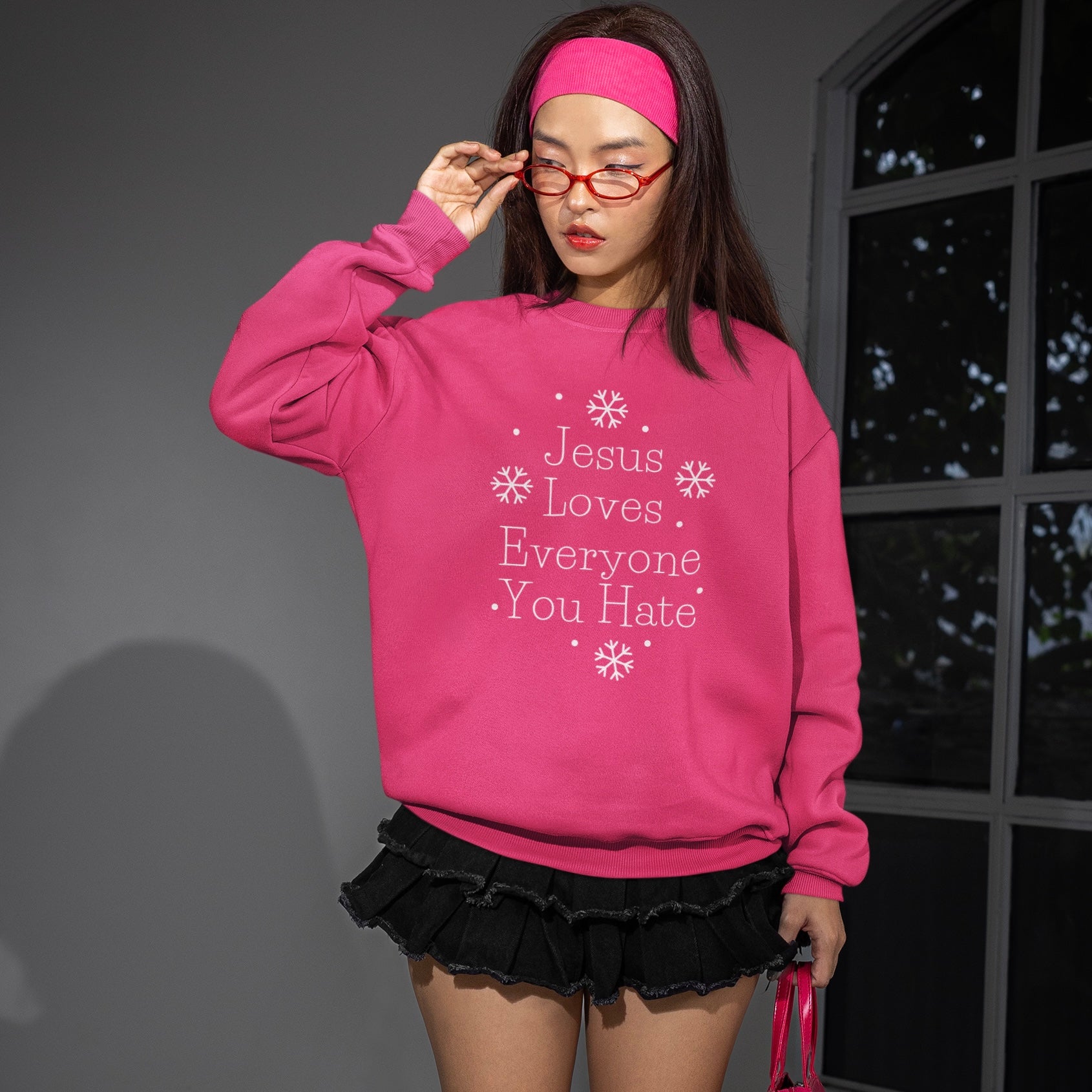 Pink political sweatshirt that says Jesus loves everyone you hate in white surrounded by snow flake illustrations. Shop feminist trash for political clothing