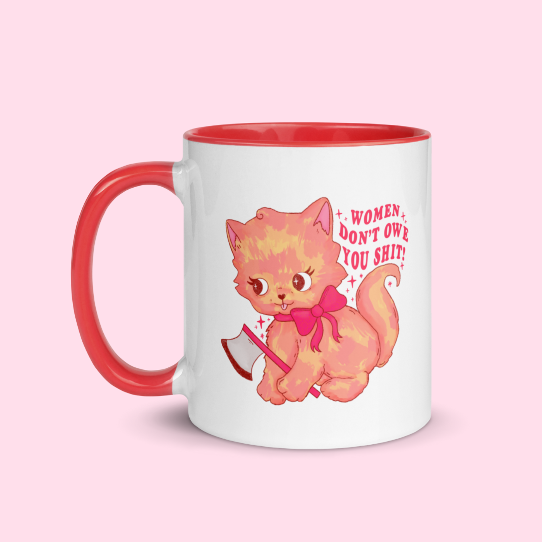 White ceramic feminist mug with red handle and interior, featuring bold red text that says 'Women don't owe you shit' and a playful illustration of a cat holding a knife. Add a touch of empowerment to your mornings with this vibrant feminist mug