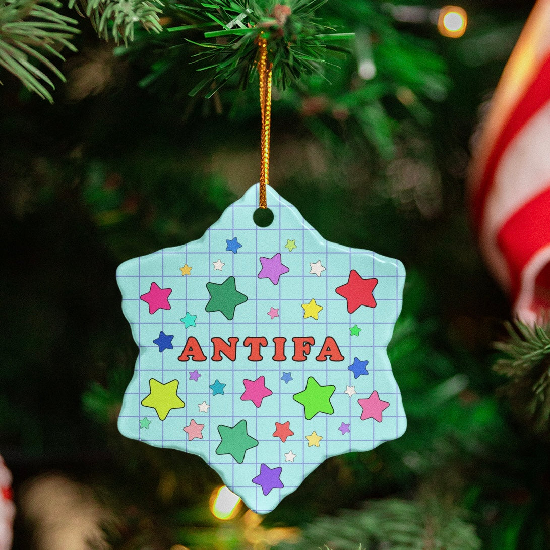 blue snow flake shaped ceramic christmas ornament that says Antifa surrounded by stars- shop feminist trash for feminist merch and christmas decorations