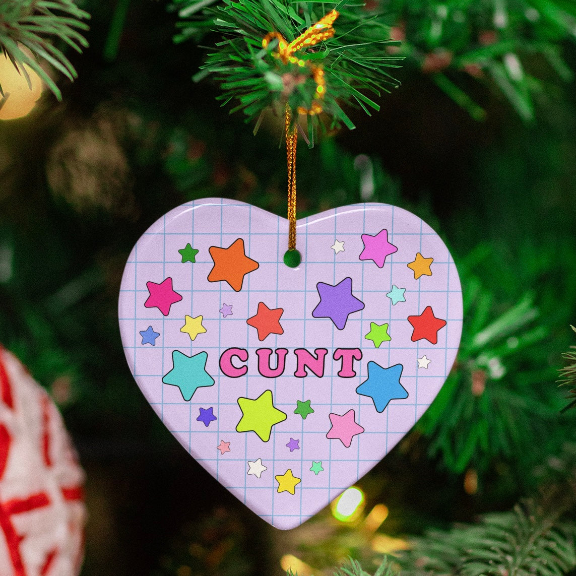 purple heart ceramic christmas ornament that says cunt surrounded by stars- shop feminist trash for feminist merch and christmas decorations