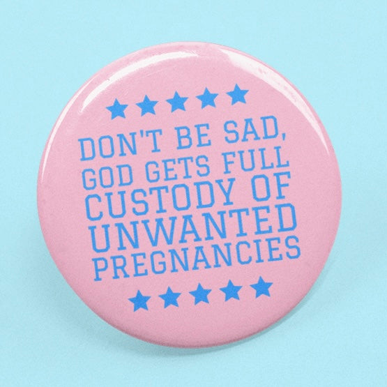 pink feminist pin that says don't be sad, god gets full custody of nwanted pregnancies in blue writing- shop feminist trash for pro choice pins and feminist apparel