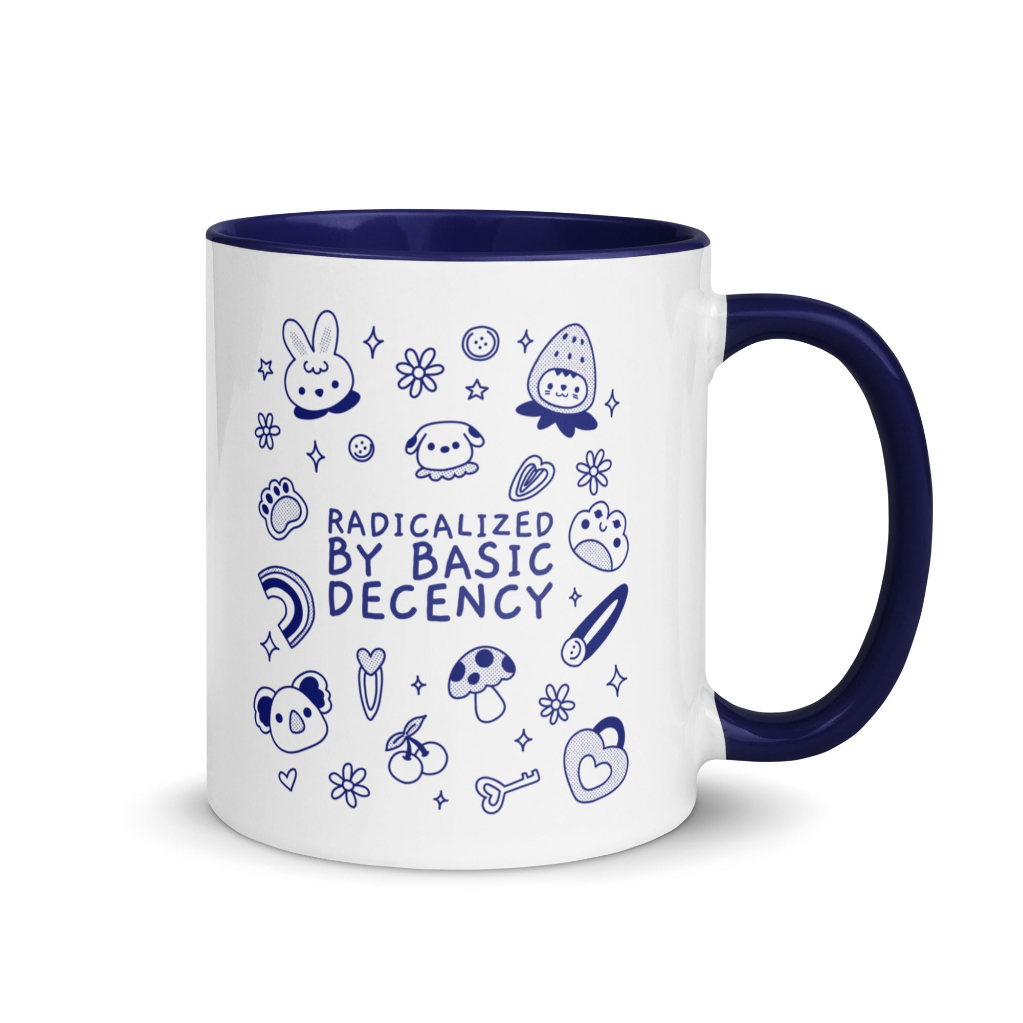 A "Radicalized by Basic Decency" political mug sitting on a modern office desk next to a laptop and a houseplant, illustrating feminist home decor and activist office accessories.