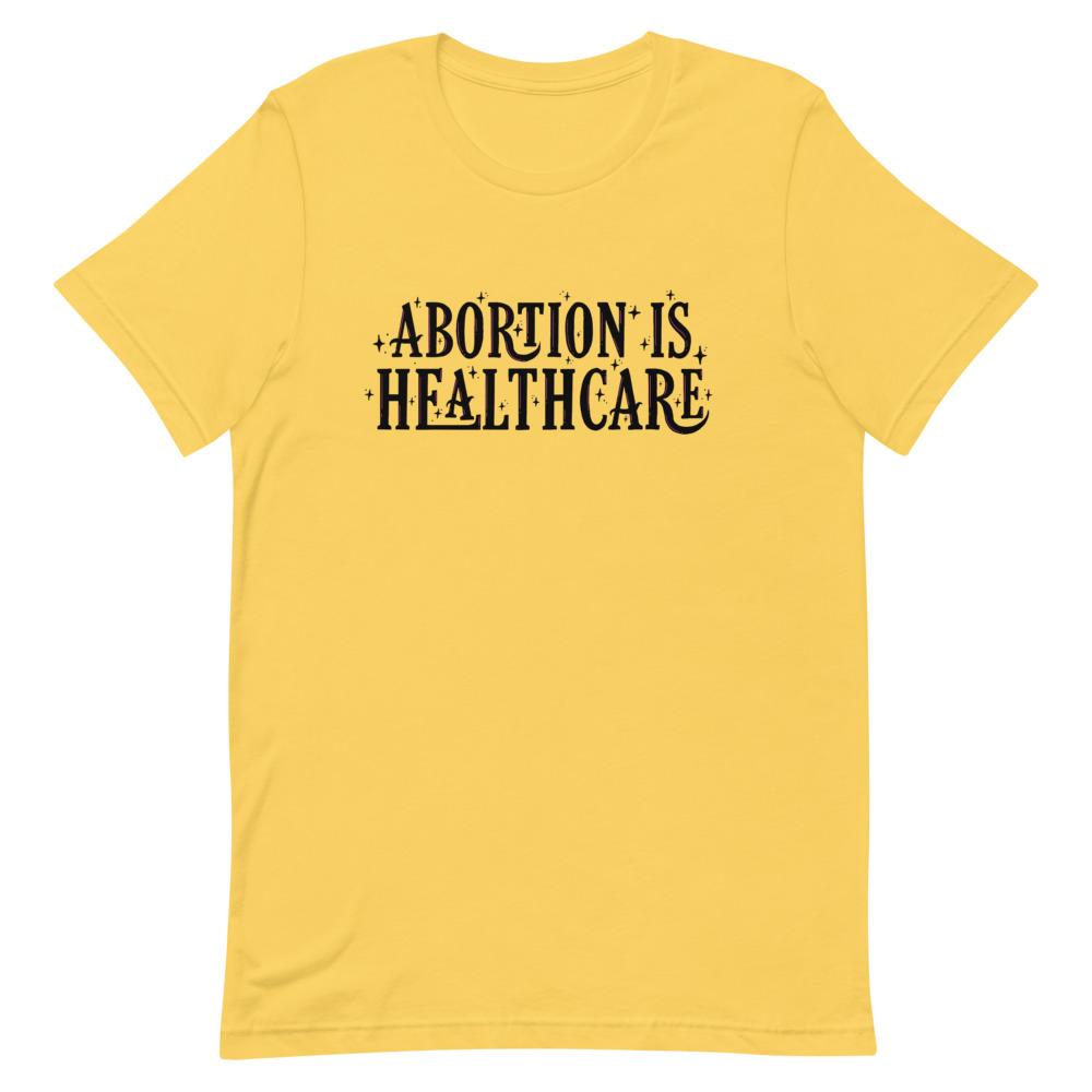 Yellow feminist shirt showcasing the importance of 'Abortion is Healthcare' in black lettering- shop feminist apparel