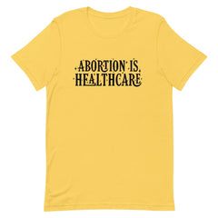 Yellow feminist shirt showcasing the importance of 'Abortion is Healthcare' in black lettering- shop feminist apparel