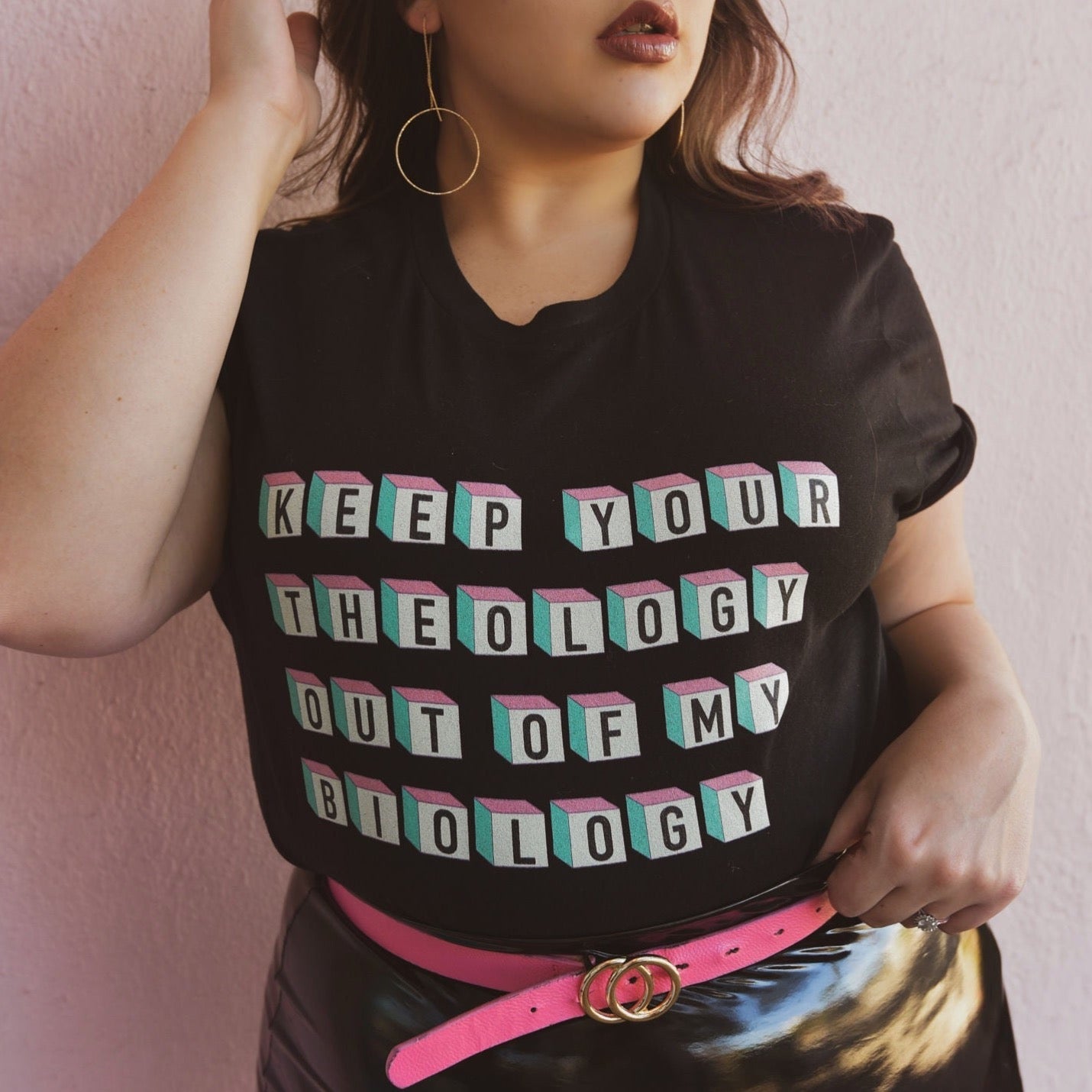 Empowering black feminist shirt featuring the strong message "Keep Your Theology Out of My Biology- Shop Feminist Trash Store for feminist tees, Pride merch and dump him shirts