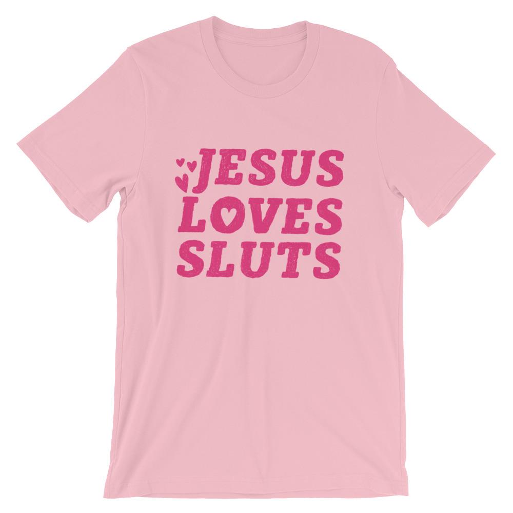 Pink feminist t-shirt that says 'Jesus Loves Sluts' in red hand lettered writing- shop Feminist Trash for feminist apparel, political clothing, acab t-shirts, pride outfits and dump him shirts.