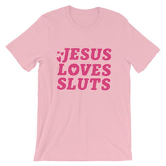 Pink feminist t-shirt that says 'Jesus Loves Sluts' in red hand lettered writing- shop Feminist Trash for feminist apparel, political clothing, acab t-shirts, pride outfits and dump him shirts.