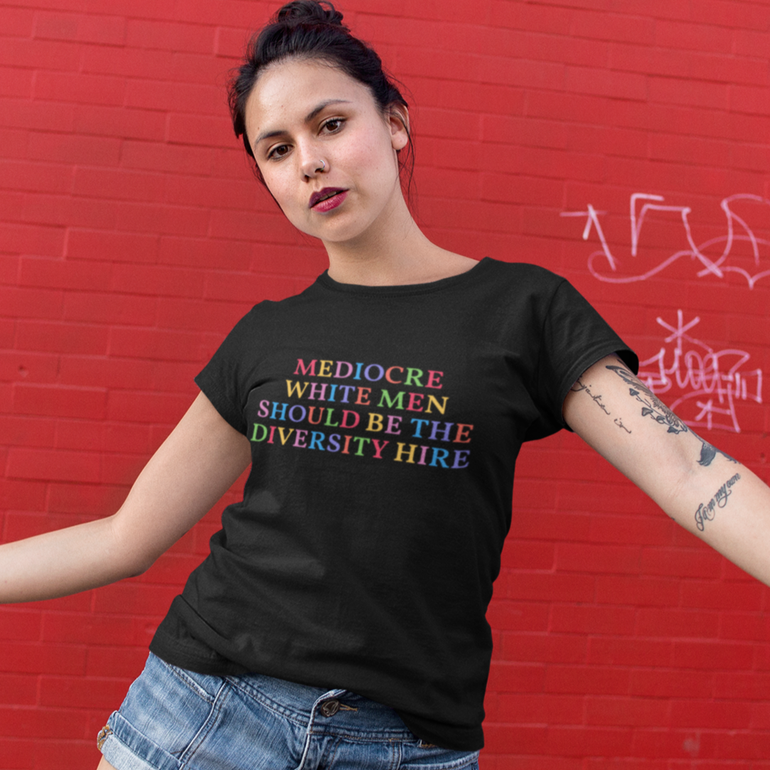 Black feminist t-shirt that says 'Mediocre White Men Should Be The Diversity Hire' in rainbow writing- shop feminist trash for political clothes, feminist tees and dump him shirts