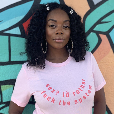 Pink feminist t-shirt boldly featuring "Sex? I'd Rather Fuck The System" in red writing