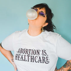 Feminist t-shirt in white advocating 'Abortion is Healthcare' and women’s rights- Shop women's empowerment tees