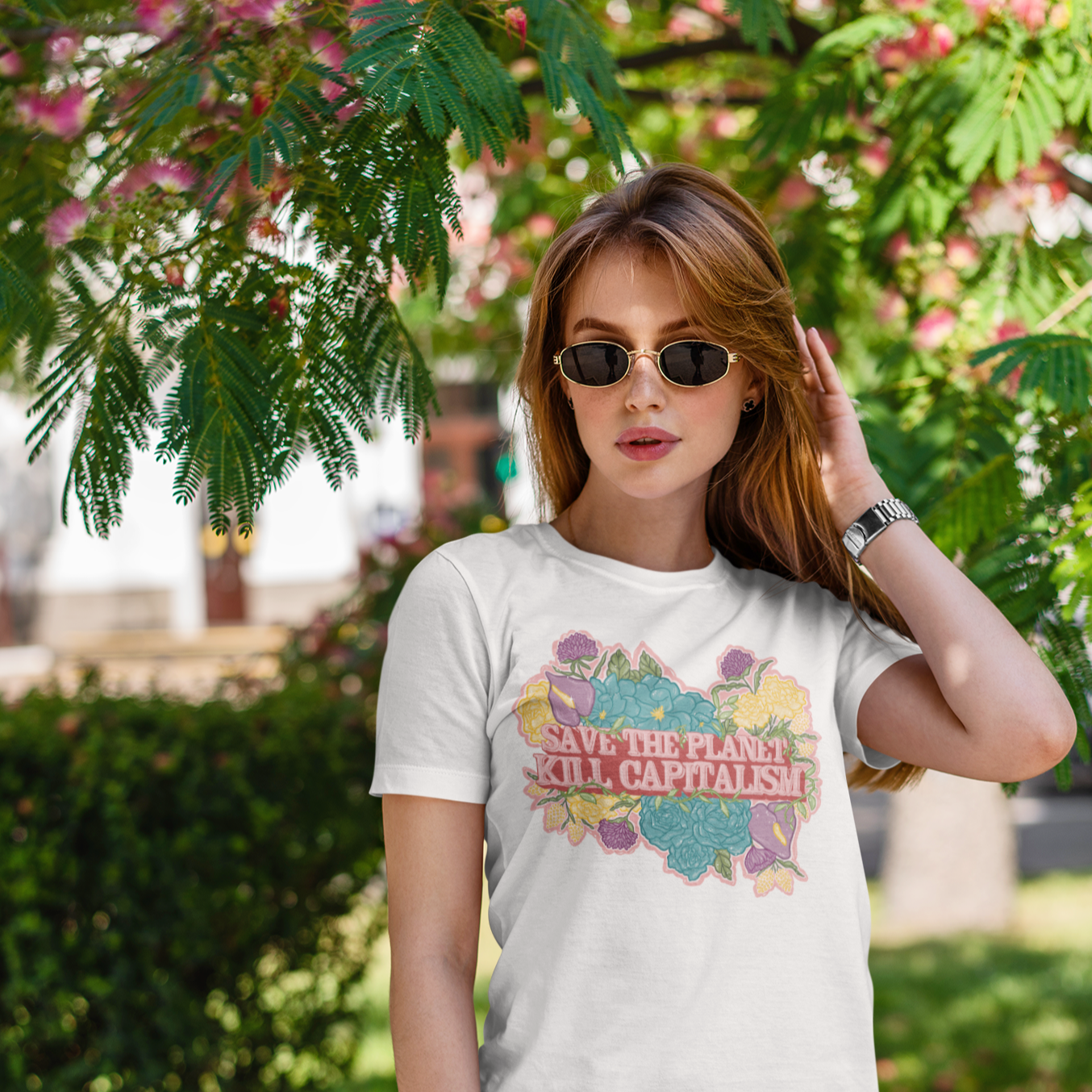 White feminist t-shirt spreading message: "Save The Planet Kill Capitalism." with a floral illustrated background- shop feminist apparel political clothing and acab t-shirts