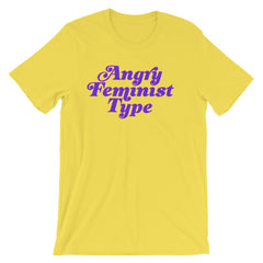 Yellow feminist t-shirt conveying: "Angry Feminist Type." in purple retro writing. define feminism with our feminist tshirts, cat lady t shirts, political clothing, dump him sweatshirts, pride tshirts, and witchy outfits