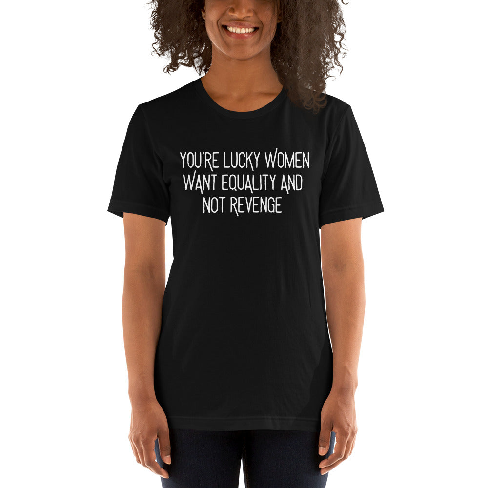 A smiling person wearing the black "You’re Lucky Women Want Equality And Not Revenge" graphic tee. Styled as a casual activist outfit, showcasing the fit and scale of the Feminist Trash apparel line.