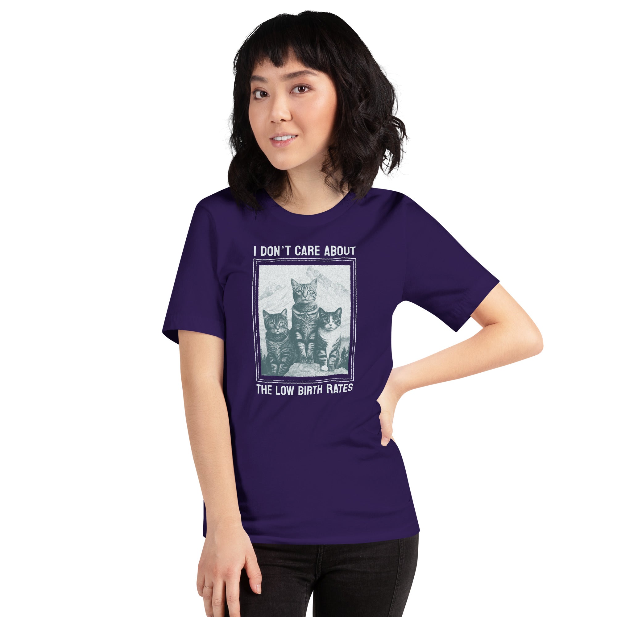 A person wearing the purple "I DON'T CARE ABOUT THE LOW BIRTH RATES" cat t-shirt, styled as a casual activist look. Showcases the fit and scale of the graphic design.