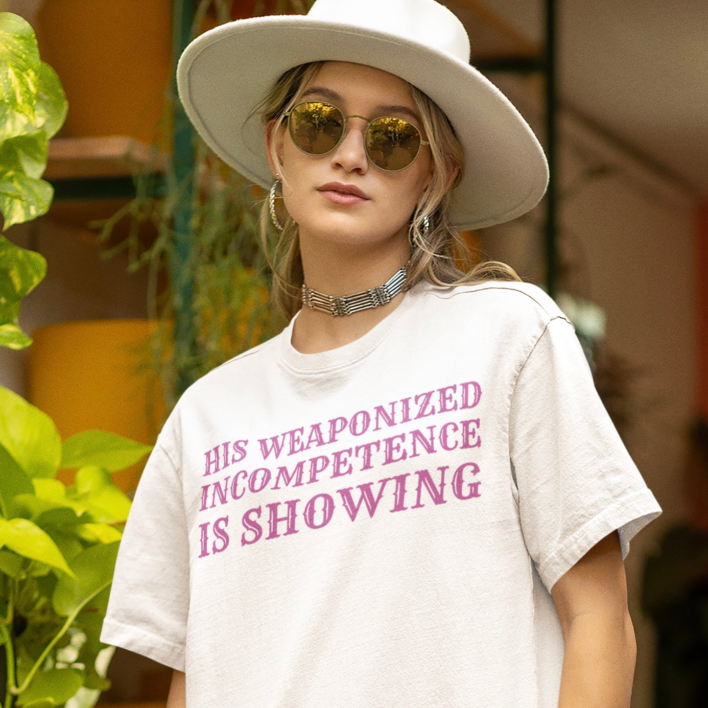 white feminist t-shirt that says his weaponized incompetence is showing in purple cowboy writing- shop feminist trash for women's march merchandise and feminist apparel