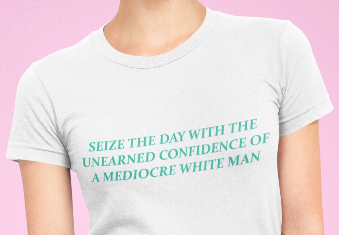 White Feminist T-shirt that says Seize The Day With The Unearned Confidence Of A Mediocre White Man in light teal writing- Shop Feminist Trash Store for funny t shirts for women, political clothing, acab t-shirts and dump him shirts