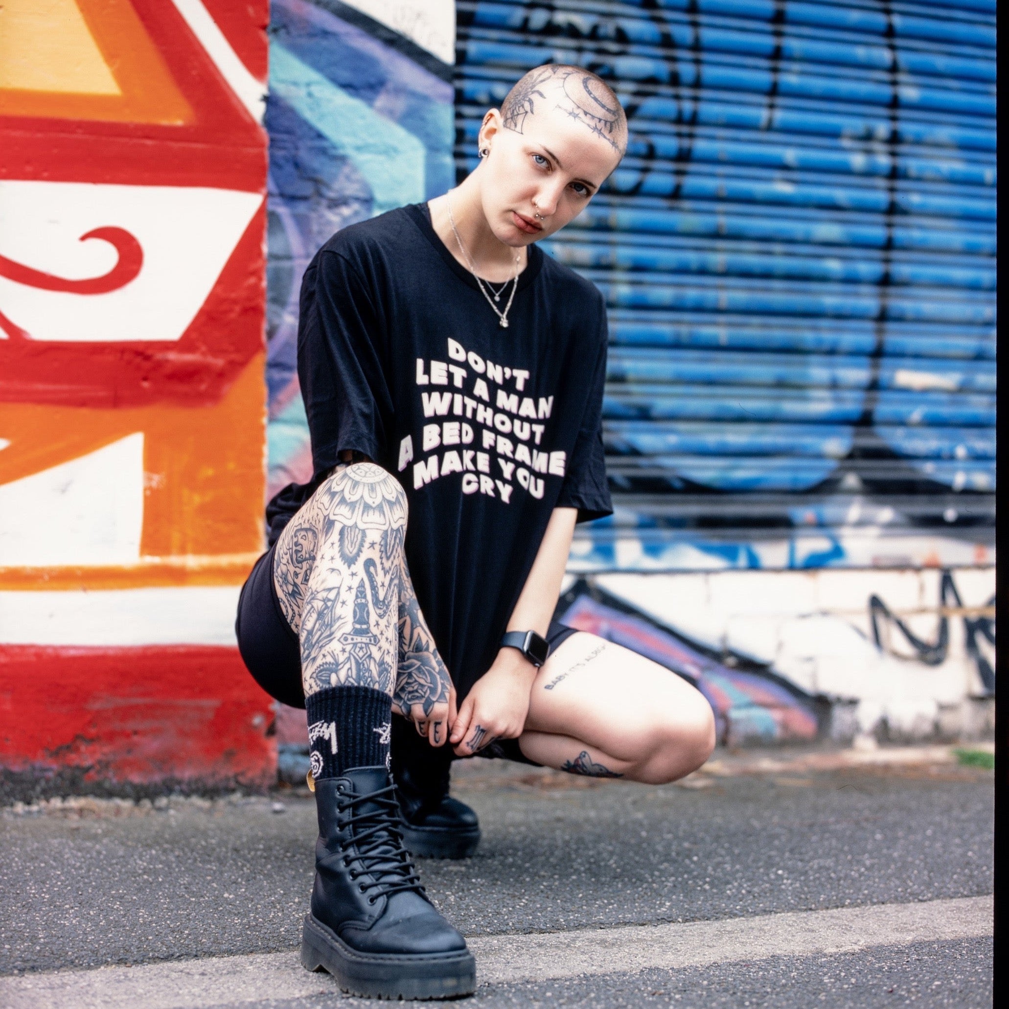 Women's rights t-shirt in black asserting "Don't Let a Man Without a Bed Frame Make You Cry"