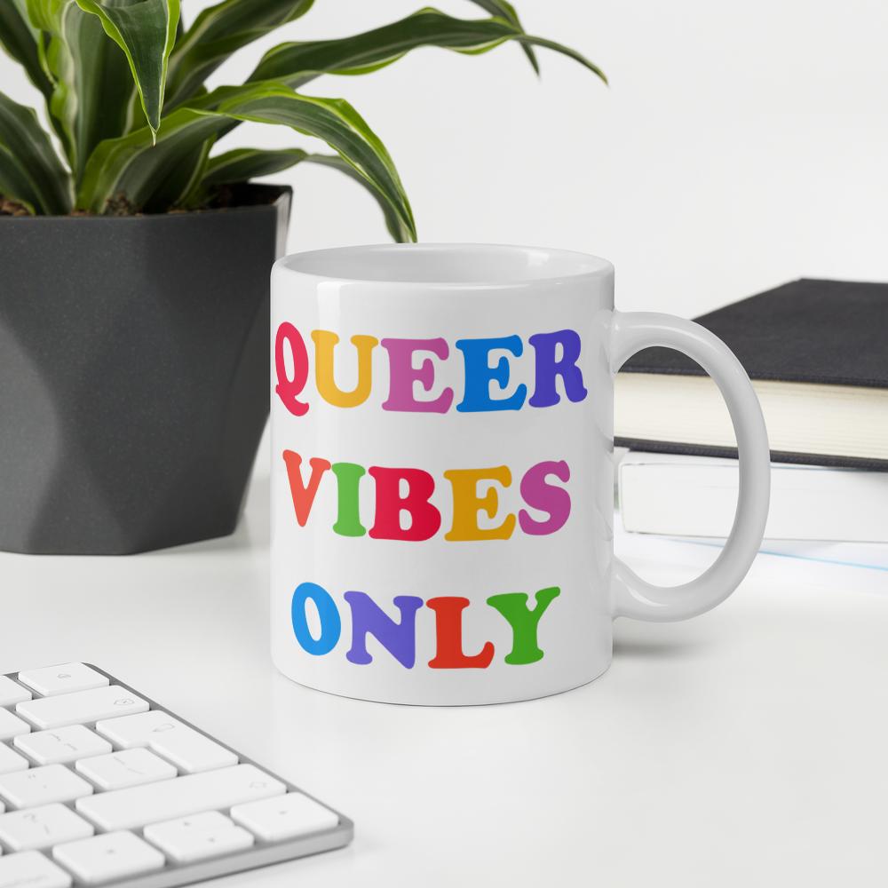 11 oz Pride mug that says Queer Vibes in rainbow retro writing- shop feminist trash for pride clothing, political t shirts, feminist apparel and dump him shirts