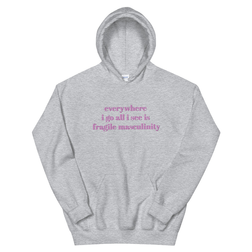 Grey feminist hoodie that says Everywhere I Go All I See Is Fragile Masculinity in purple lowercase font Shop Feminist apparel and dump him shirts