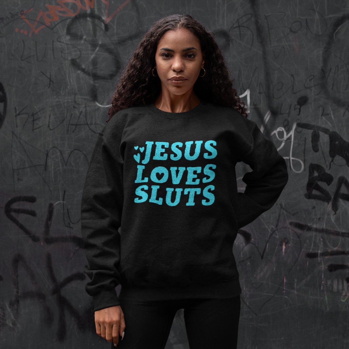 Black feminist sweatshirt that says Jesus Loves Sluts in blue bold hand lettered writing featuring heart illustrations. Shop Feminist Trash Store for feminist t shirts and political clothing.