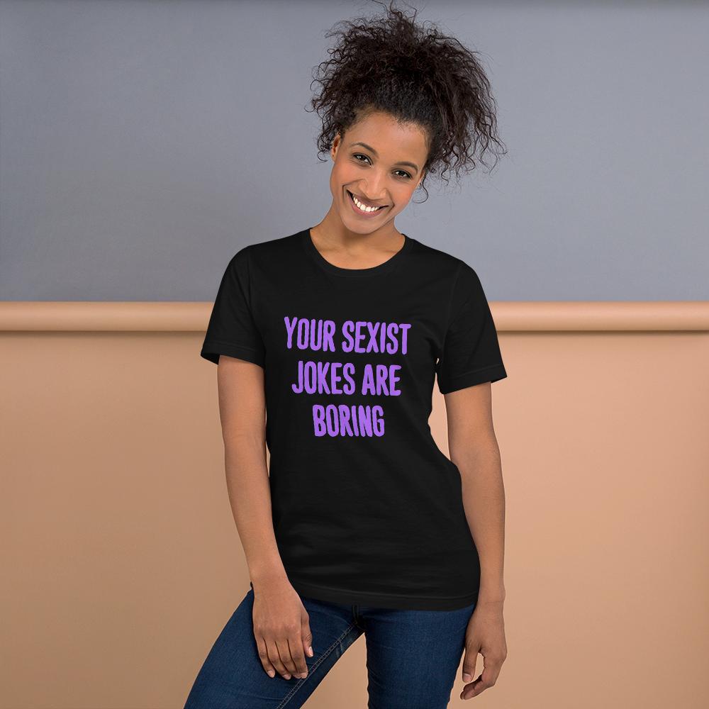 bllack feminist t-shirt that says Your Sexist Jokes Are Boring in bold purple writing. Define feminism with our feminist apparel, political clothing, pride clothing, and dump him shirts