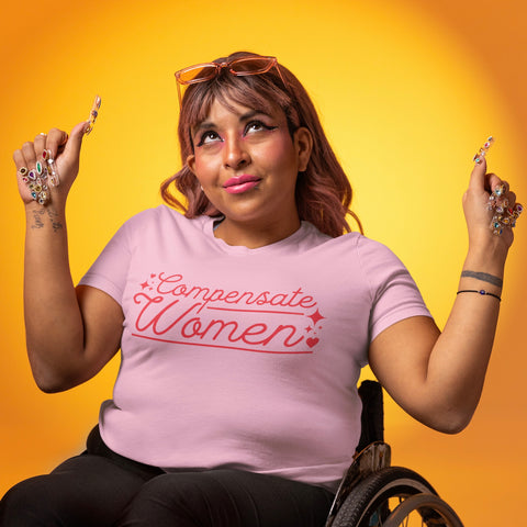 pink feminist shirt that says compensate women in red writing- shop feminist trash for equality tshirts and feminist tees