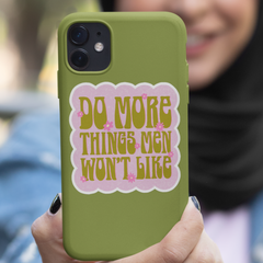 funny feminist sticker that says do more things men won't like in a lime army green 70s retro font with pink flower details and a bubble pink background.