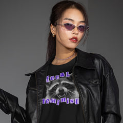 black raccoon tshirt that says feral feminist in purple ransom style writing featuring a black and white raccoon photography- Shop feminist trash for funny t-shirts for women and feminist clothing