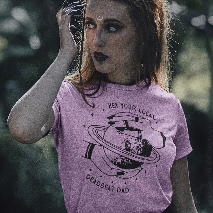 Lilac feminist tee that says hex your local deadbeat dad. Featuring witchy hands around Saturn. Shop feminist trash for feminist apparel and political shirts 