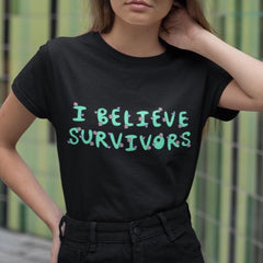 black feminist t-shirt that says  believe survivors in green bubble writing with tiny purple daisy illustrations. Shop Feminist Trash for political clothing, pride outfits, feminist apparel, dump him shirts and witchy outfits