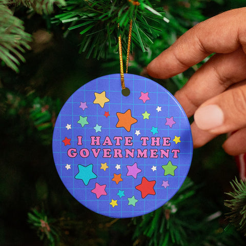 Political Christmas ornament that says I hate the government in pink writing surrounded by stars. Shop feminist trash for political clothing and Christmas decorations 