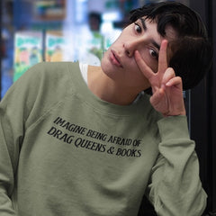 army green sweatshirt that says imagine being afraid of drag queens and books in bold black writing. Shop feminist trash for political clothes, pride merch and feminist shirts