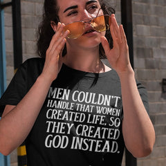 black feminist shirt that says Men couldn't handle that women created life, so they created god instead. In white uppercase writing- Shop Feminist Trash for feminist t-shirts, dump him shirts, political clothing and pride merch.