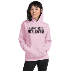 pink feminist hoodie that says abortion is healthcare in black hand lettered writing- shop social justice apparel