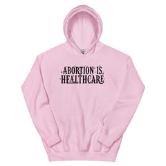 pink feminist hoodie that says abortion is healthcare in bold black hand lettering