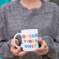 White pride mug featuring rainbow hand lettering that says queer vibes only. Celebrate pride with this not so subtle queer mug