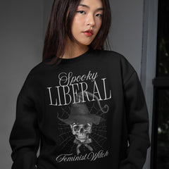 Black feminist sweatshirt that says spooky liberal feminist witchy in white writing- featuring a skull witch watercolour illustration. Shop feminist trash for witchy outfits and feminist clothing
