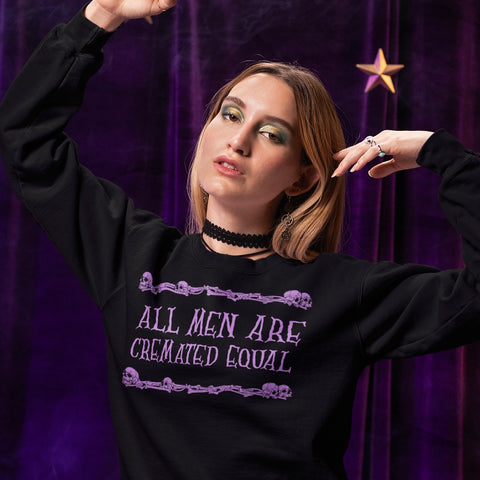 black feminist sweatshirt that says all men are cremated equal in purple writing- shop feminist trash for funny feminist sweatshirts and witchy outfits