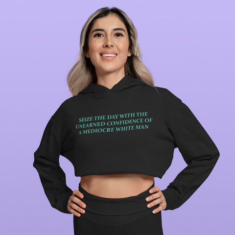 Black feminist cropped hoodie featuring 'Seize the Day with the Unearned Confidence of a Mediocre White Man' text, promoting empowerment and challenging norms. Shop feminist apparel